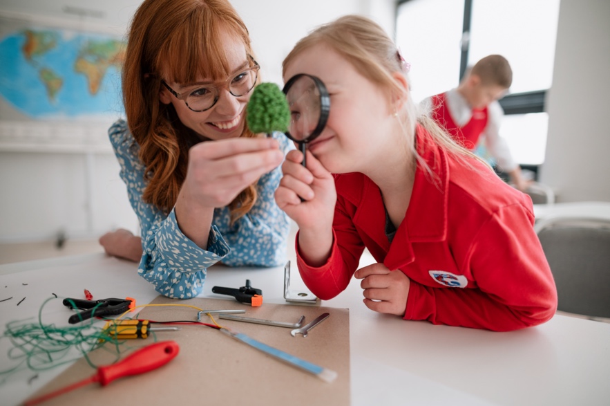 Teacher and student with magnifying glass